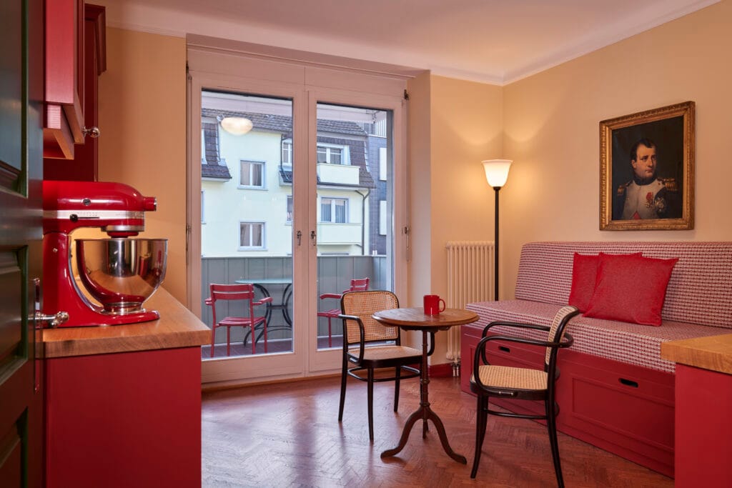 Rote retro Holzküche im Vintage Stil mit Thonetstühlen und Jugendstil Leuchte
