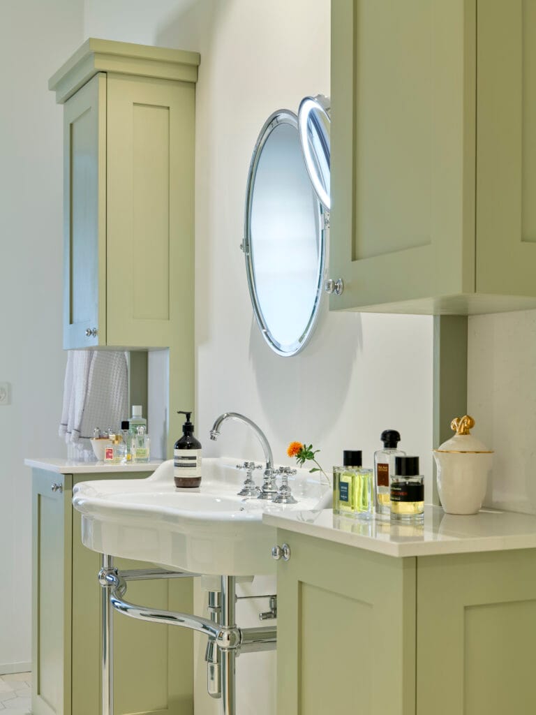 Designbad mit ovalem Spiegel massgefertigte Schranke in Nische für Grandhotel Lavabo mit Luxusarmaturen im retro Stil